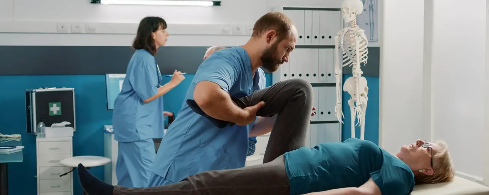 A clinician assessing a patient lying on a treatment table in a clinical assessment room